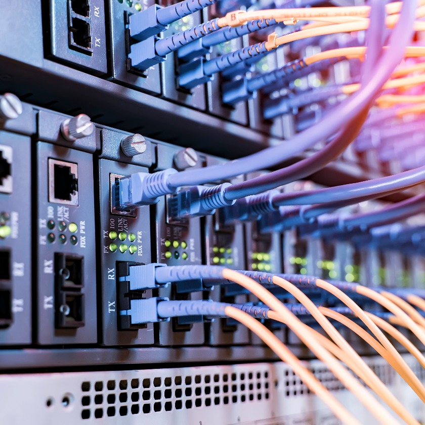 server rack with fiber optic cables attached to front panel switch ports